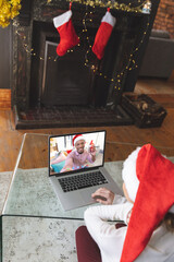 Poster - Caucasian woman having christmas video call with african american man