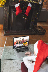 Poster - Caucasian woman having christmas video call with diverse people