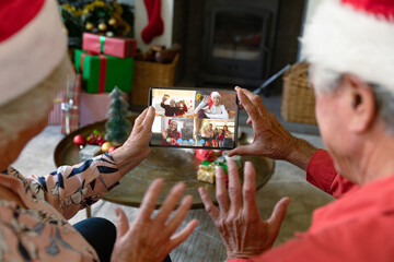 Poster - Senior caucasian couple having christmas video call with diverse people