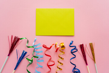 Wall Mural - top view of empty greeting card near drinking straws with tinsel and serpentine on pink background.