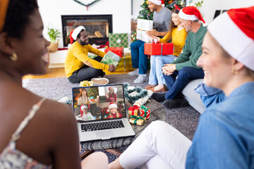 Poster - Diverse friends with christmas decorations having video call with happy caucasian friends