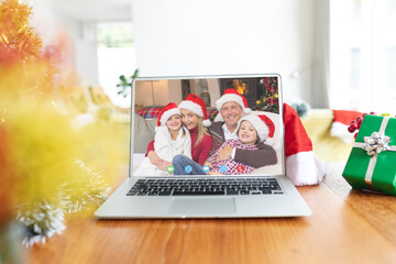 Poster - Happy caucasian family having christmas laptop video call on table