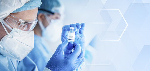 Wall Mural - research scientist holding vaccine bottle in hand on modern clinical laboratory background