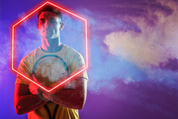 Wall Mural - Portrait of caucasian male tennis player holding racket by illuminated hexagon, copy space