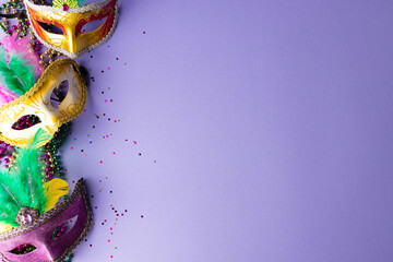 Wall Mural - composition of colourful mardi gras beads and carnival masks on blue background with copy space