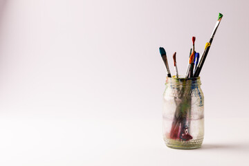Canvas Print - Image of close up of jar with paint brushes and copy space on cream background