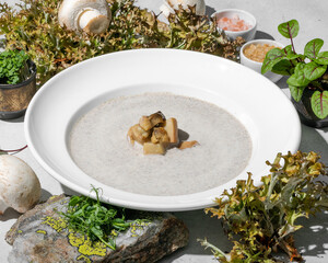 Poster - Mushroom cream soup with herb garnish a light background with copy space, nature background