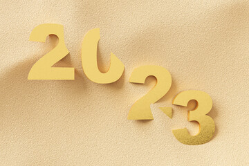 Wall Mural - 2023 gold number on sand beach abstract background. Happy new year and holiday concept.