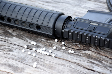 Wall Mural - BB gun or airsoft gun muzzle and white bullets on wooden plank, soft and selective focus.