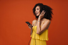 Young Joyful Afro Woman Listening Music With Headphones And Mobile Phone Isolated