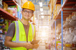 © เลิศลักษณ์ ทิพชัย - Retail warehouse full of shelves with goods Male clerk holding a stock checking tablet while scanning parcels logistics distribution center