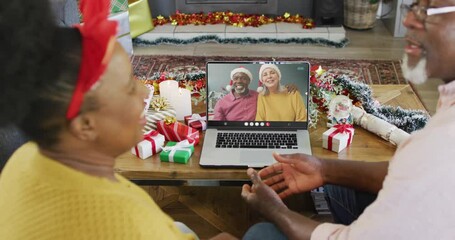 Sticker - Animation of senior biracial couple on laptop video call with friends at christmas