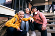 © CarlosBarquero - Group of three students outside the school looking at the camera. College classmates sitting on a staircase on campus university.