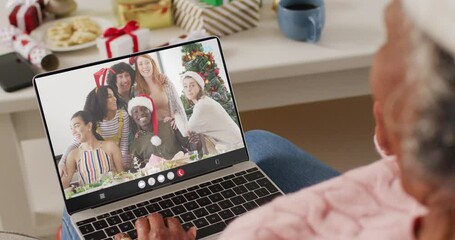 Wall Mural - Senior african american woman having christmas video call with diverse people