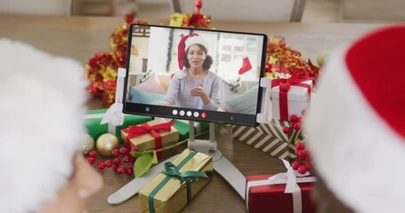 Wall Mural - Diverse couple having christmas video call with african american woman