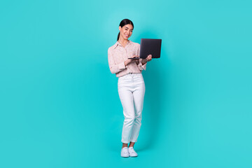 Wall Mural - Full size photo of successful indonesian person hold use netbook isolated on vibrant emerald color background