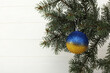 Yellow-blue New Year's ball as the colors of the Ukrainian flag. Closeup of Christmas Yellow-blue ball on Christmas Tree beautiful background for design and decoration, new year concept.