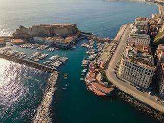 Panoramic drone view of the entire city of Naples in southern Italy. Flight over historical landmarks in Naples, Italy. Historic egg castle (castel dell'ovo) on the waterfront of the Gulf of Naples