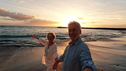 Wall Mural - Portrait of two cute old persons having fun and enjoying together at the beach on sunny days at the beach. Looking and holding a camera videos of vacations