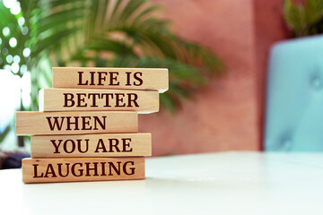 Wooden blocks with words 'Life is Better When You Are Laughing'.