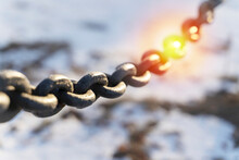 Black Chain On A Background Of Sunlight And Snow, Selective Focus