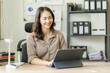 © ArLawKa - Asian woman holding a windmill Simulate wind energy examples and advice on alternative energy in an online meeting in front of a tablet computer in the office.