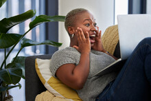Laptop, Surprise And Excited Black Woman On Sofa Shocked With Win Of Digital Lottery, Competition Or Award. Wow News, Prize Winner And Girl On Gambling Website Play Online Poker, Bingo Or Casino Game