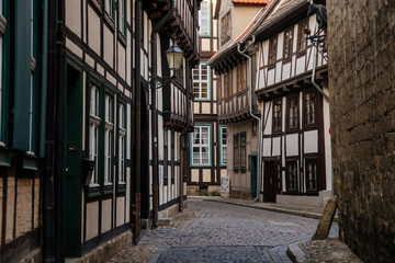 Wall Mural - Quedlinburg, Saxony-Anhalt, Germany, 28 October 2022: Historic old vintage colored timber frame houses in medieval town, UNESCO World Heritage city, half-timbered home at sunny autumn day, cobblestone