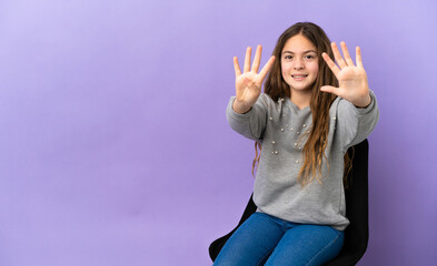 Poster - Little caucasian girl sitting on a chair isolated on purple background counting nine with fingers