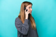 © luismolinero - Young caucasian woman isolated on blue background keeping a conversation with the mobile phone with someone