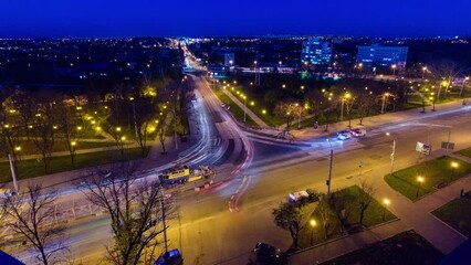 Wall Mural - Road intersection with reconstructed tram tracks aerial day to night transition timelapse. Kharkiv city from above. Tram stop and car traffic on the Moscow avenue and Academic Pavlov street. View to