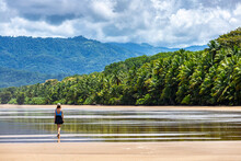 A Lone Beautiful Girl In A Skirt Walks Along A Tropical Beach With Palm Trees In Marino Ballena National Park In Costa Rica; Relaxing On A Paradise Beach In Costa Rica