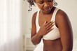 © Studio Romantic - Beautiful young black woman in underwear suddenly feels pangs of pain and touches her chest. Heart attack, infarct, cardiac disease, mastitis, breast cancer symptoms concept