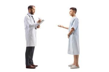 Poster - Full length profile shot of a male doctor and a young male patient in a hospital gown standing and talking