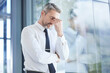 © Nadia L/peopleimages.com - Window, business man and stress with headache, burnout and overworked in office. Senior male, entrepreneur and ceo frustrated, mental health and leader with depression, pain and tired in workplace.