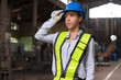 © chachamp - Portrait beautiful and confident Latin America woman engineer touching helmet at factory