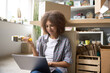 © Svitlana - Smiling woman using laptop in her own shop