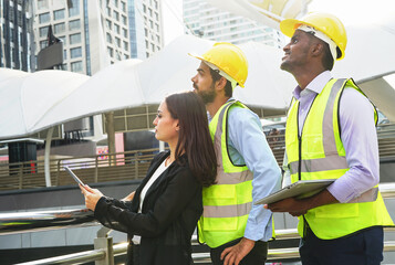 engineers team are discussing while inspecting at construction site, multiracial business engineering man and woman are working outdoors in the urban