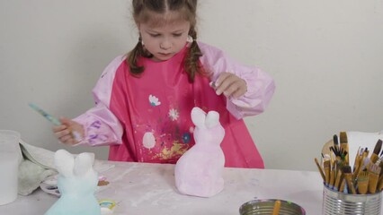 Sticker - Little girl painting paper mache figurine at homeschooling art class.