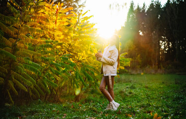 Wall Mural - Lifestyle autumn girl relaxing. Portrait of beautiful young lady sitting on nature.