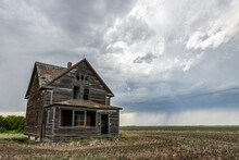 Old Farmstead On The Prairies Under Storm Clouds; Val Marie, Alberta, Canada