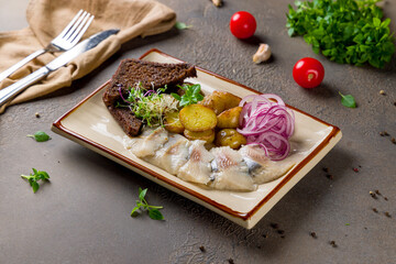 Wall Mural - Herring with potatoes and red onion on brown table