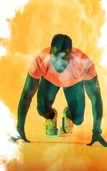 Wall Mural - Confident african american male athlete at starting position against yellow smoky background