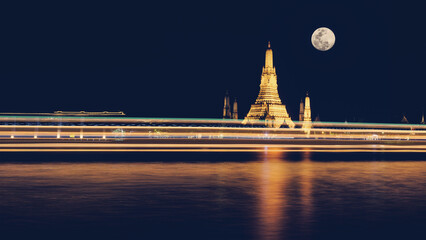 Wall Mural - wat arun pagoda on Chao Phraya river bank at night with fullmoon and light trail