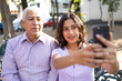 © Creative Sparks - Teen girl and her grandfather taking a selfie outdoors.