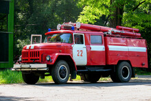 Red Fire Truck Of The Times Of The Ussr Against The Background Of Green Trees