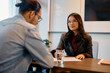 © Drazen - Happy Asian businesswoman during job interview with male candidate in office.