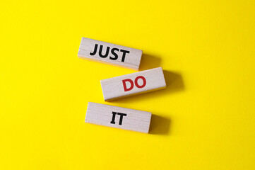 Just do it symbol. Wooden blocks with words Just do it. Beautiful yellow background. Business and Just do it concept. Copy space.