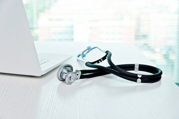 Stethoscope and laptop on doctor working desk