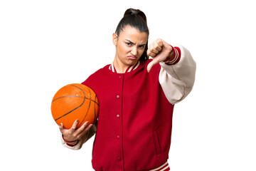 Wall Mural - Young Woman playing basketball over isolated chroma key background showing thumb down with negative expression